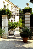 Wrought iron gate with ornaments at the entrance to a classical property