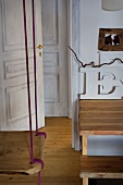 Swing suspended from ceiling and open door in rustic setting