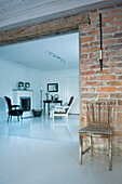 Wohnzimmer mit Kamin, Backsteinwand und kontrastierenden Stühlen