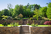 Well-kept garden with stone walls and staircase in summer