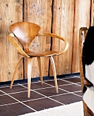 Fifties-style wooden chair in front of wooden wall