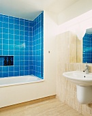 Modern bathroom with blue tiling around bathtub