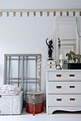 White chest of drawers with mirror, old window frames as decoration, bedroom
