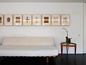 White sofa with side table and pictures on wall