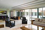 Elegantes Wohnzimmer mit Sitzmöbeln und Glasfront zu der Terrasse