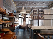 English restaurant in historic hall with ornamented ceiling and old counters with modern steel and glass shelving on marble slabs