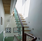 Offene Treppe mit Geländer aus Glaspanelen im modernen Treppenhaus