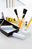 Painter's utensils: rollers, brushes, paint and spirit level