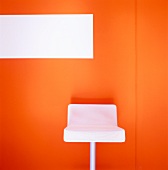 White barstool against orange wall