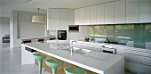 White designer kitchen with island in open-plan living space