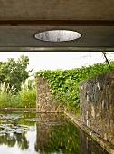 Teich mit Natursteinmauern vor Wohnhaus