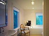 Rococo chair in front of modern bathtub