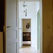 Open doors and view through hallway to hunting trophy on wall