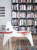 White chair in front of bookshelf in a living room