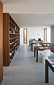 Wooden bookshelf in study with concrete floor