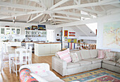 Bright living room with open-plan kitchen, white beams and vintage decor