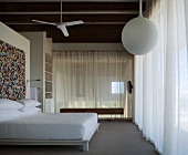 Bedroom with ceiling fan and mosaic picture on the wall