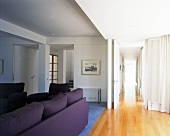 Living room with purple sofa set and open door to hallway