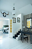 Schwarz-weiß gestalteter Raum mit Spiegel und Treppe