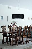 English-style dining table and chairs below modern pendant lamp in dining room