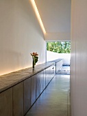 Minimalist interior with modern sideboard and indirect lighting