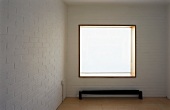 Empty room with white-painted brick wall and window