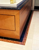 Bathtub with wood-clad sides and stone border on floor