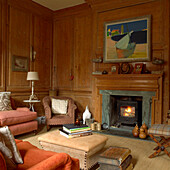 Living room with fireplace and traditional wood panelling, books on the coffee table