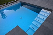 Moderner Pool mit Schieferplatten und mosaikgefliester Treppe