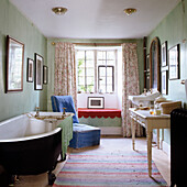 Bathroom with freestanding tub, window seat and green walls