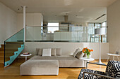 Wooden staircase with glass wall and sofa in beige