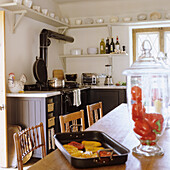 Country-style kitchen with wooden table, chairs and black cupboards