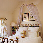 Four-poster bed with metal frame and playful decoration in the bedroom