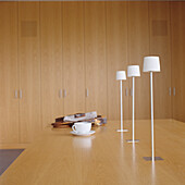 Minimalist dining area with white table lamps and wooden furniture