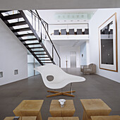 Modern living room with designer chair and art on a white wall