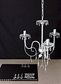 Half-decorated chandelier above organised glass decorations on black cloth