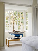 Impressive model sailing boat in bay window of white bedroom