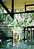 Steel and glass staircase and facade in contemporary solar house with open view of nature