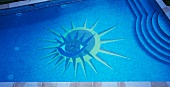 Stylised sun-and-eye motif on bottom of swimming pool