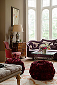 Classically furnished living room with sofa and red poufs