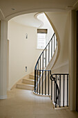 Stone staircase with black banisters in a light-coloured stairwell