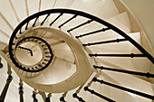 Curved stone staircase with black banisters