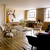 Living room with wooden floorboards, vintage furniture and brick wall