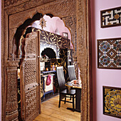 Kitchen with ornately carved wooden doorway and oriental motifs