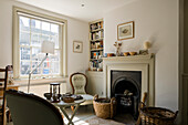 Living room with fireplace, armchair and baskets of firewood