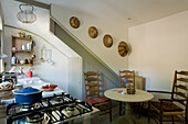 Kitchen with gas cooker, rustic wooden furniture and decorative wall baskets