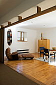 Open-plan living room with wooden floor and minimalist furnishings