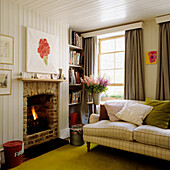 Living room with fireplace, bookshelves and cosy sofa with check pattern