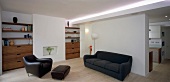 Open-plan living space with sofa, armchair & fitted shelving