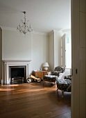A traditional fireplace room with French-style armchairs and a wooden trainer bike